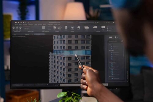 Architect engineer pointing at architectural building prototype analyzing construction model on computer. Businessman designer working remote from home at real estate project modeling sketch